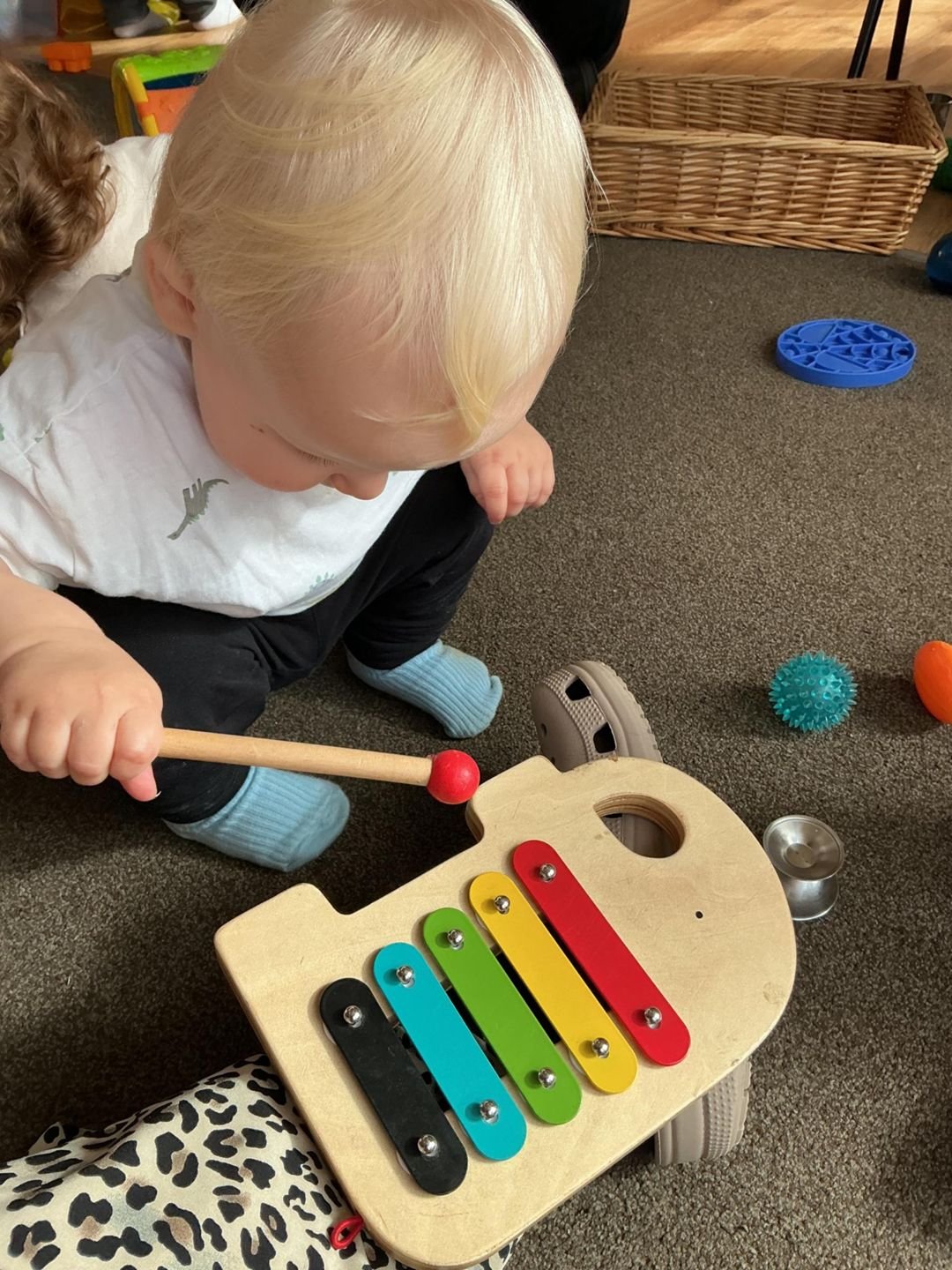 A toddler playing a xylophone